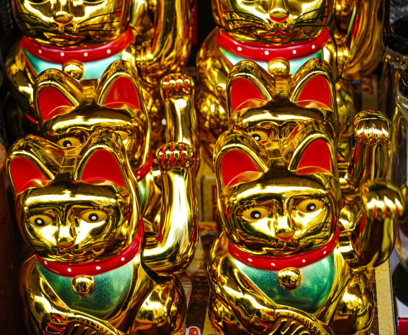 Vibrant display of golden lucky cat figurines in a Bangkok market, symbolizing prosperity.