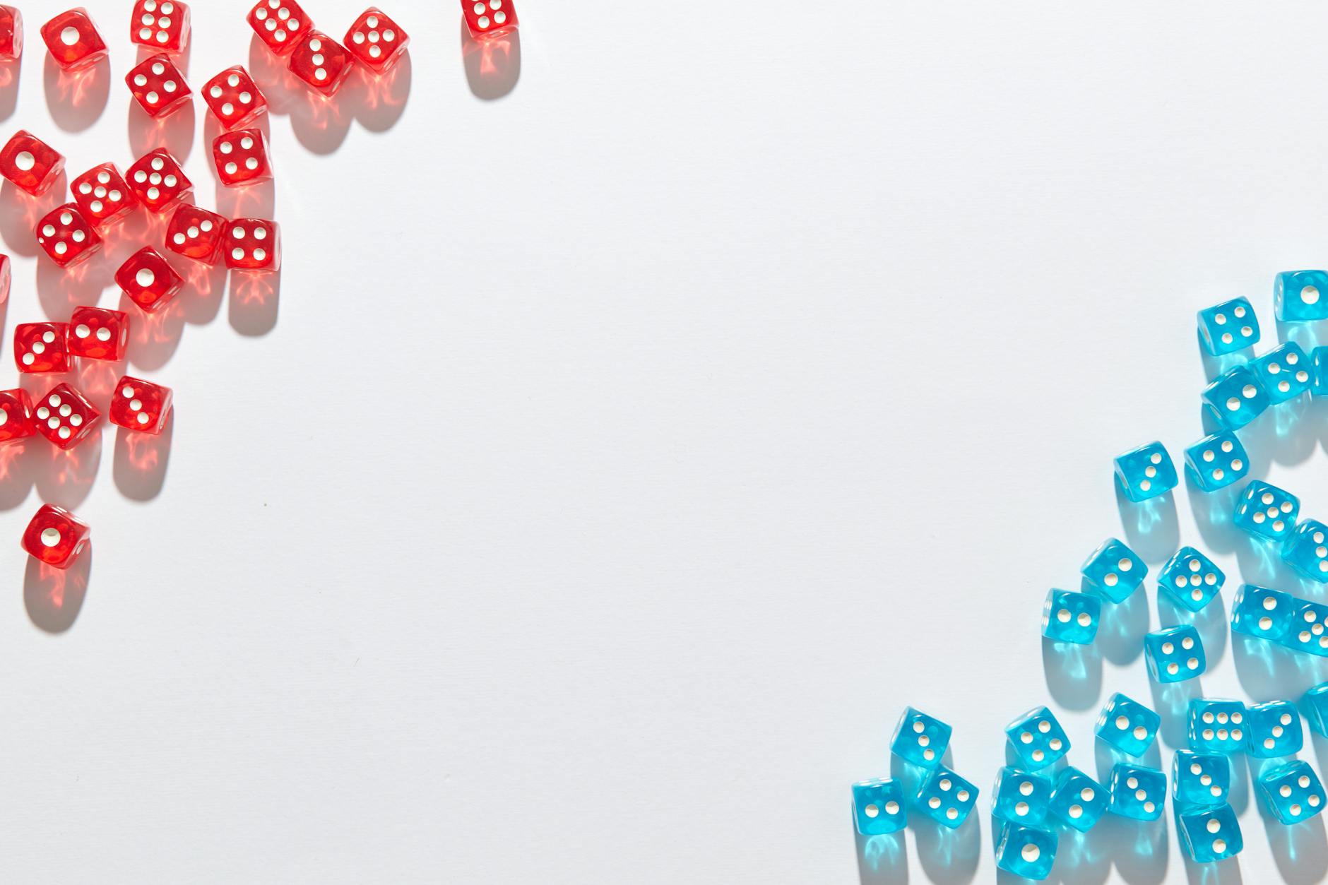 A flat lay of red and blue transparent dice on a white background, perfect for game night themes.
